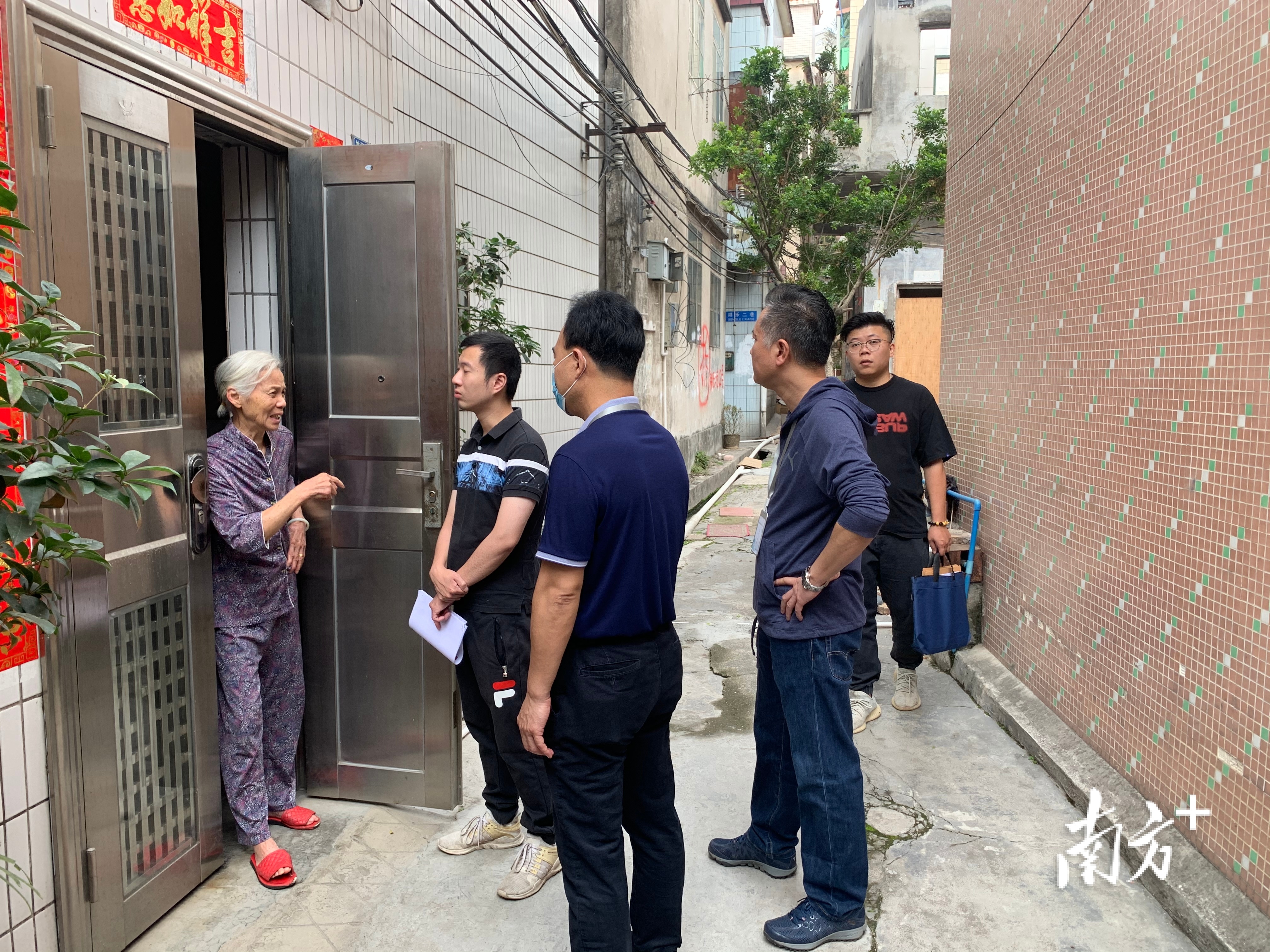 街道工作人员上门为住户讲解政策。