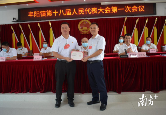 丰阳镇人大主席邱伟峰为当选的丰阳镇镇长陈先红颁发当选证。