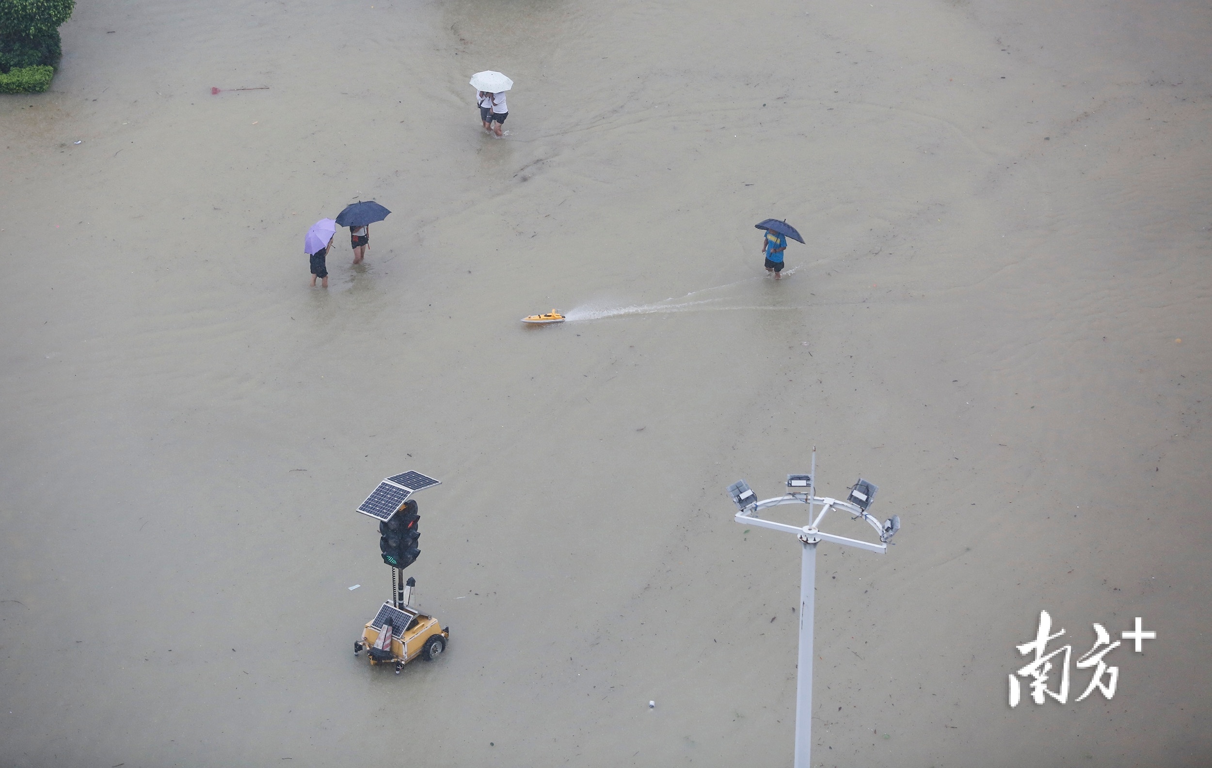 10月10日13时03分，三乡镇新城路，市民在积水处玩起遥控船模。 南方+ 叶志文 摄