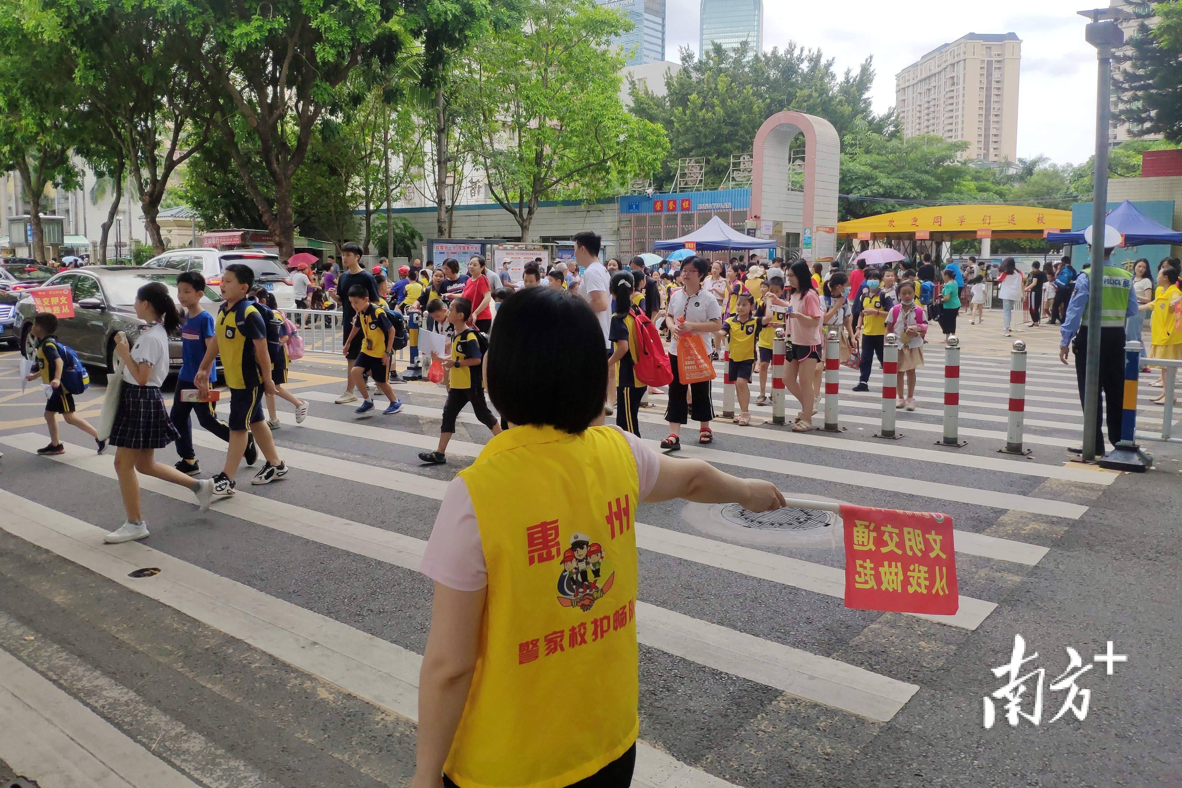 志愿者和交警在惠州一小门口维持交通秩序。 志愿者和交警在惠州一小门口维持交通秩序。