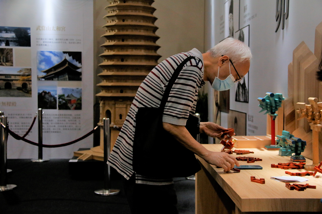 背靠祖国发展更有信心。在香港会议展览中心，市民在大国建造主题展上体验榫卯结构模型。新华社发