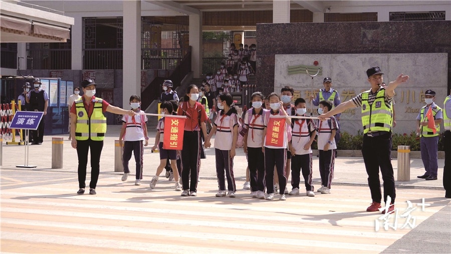 东莞义警为学生维持交通秩序。