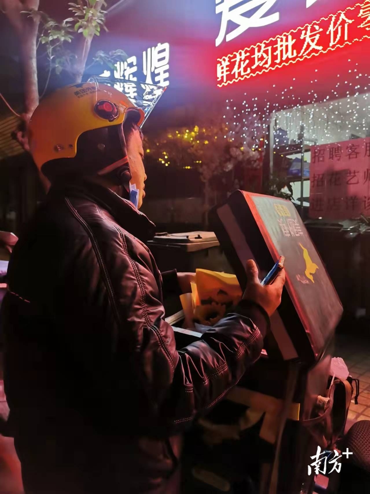 “双11”前夜，在越秀区五羊邨一处花店，等待领取鲜花的快递小哥。 &nbsp;南方+ 朱紫强 拍摄