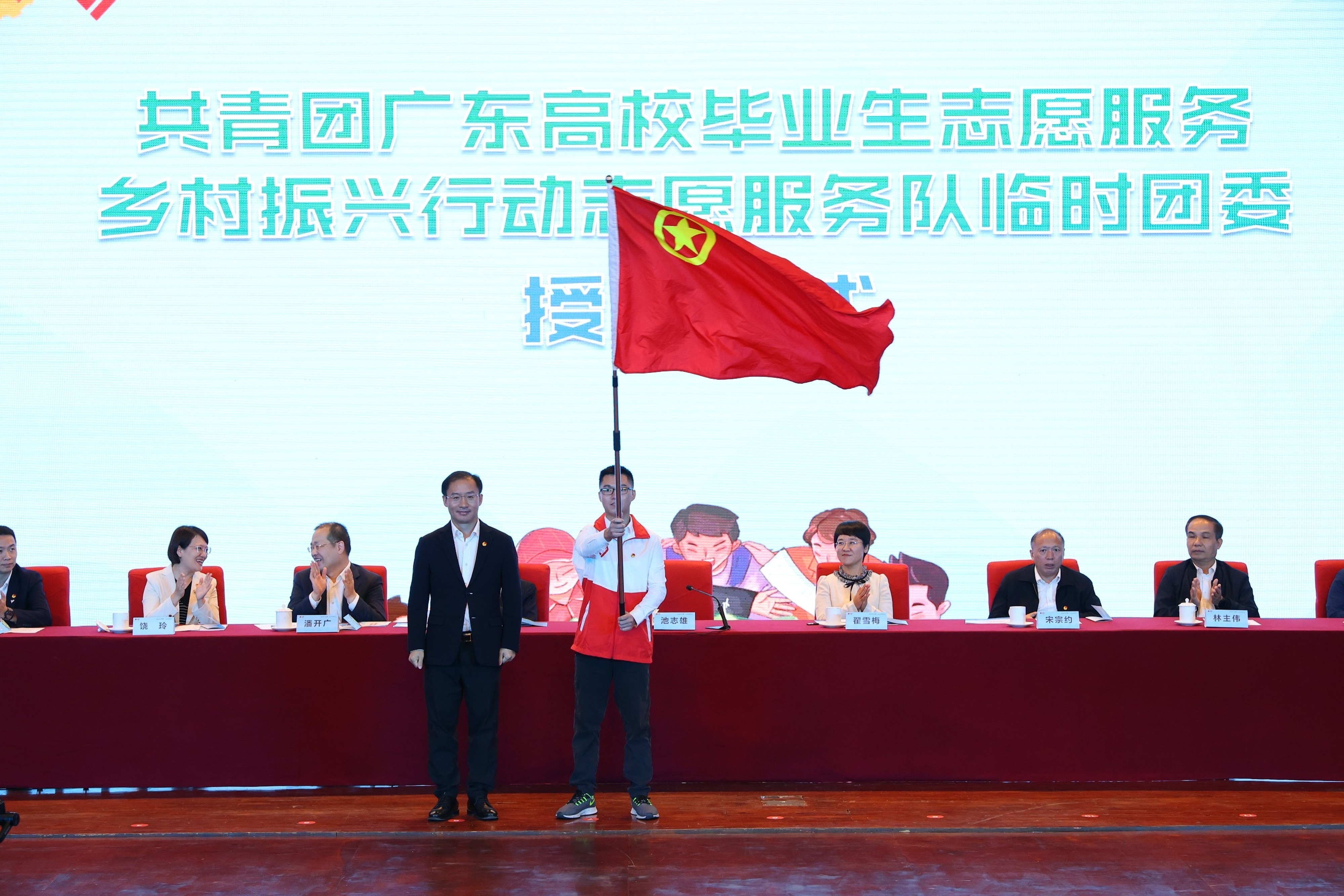 团省委书记池志雄为“志愿服务乡村振兴行动”志愿服务队临时团委授旗。 