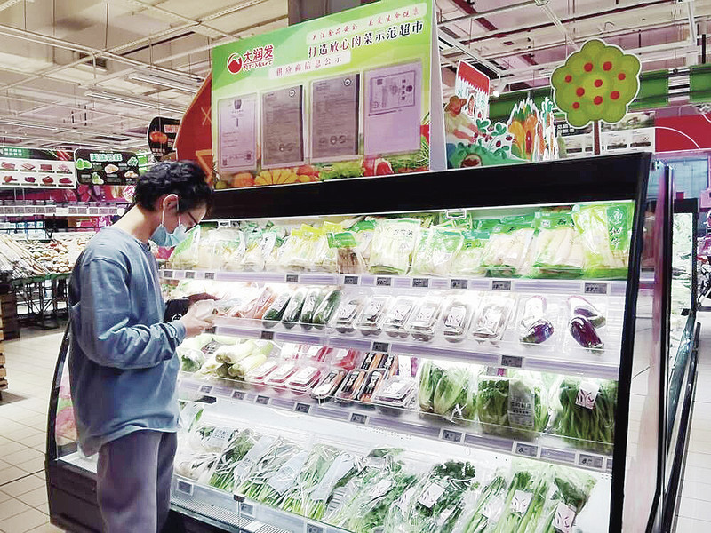 大润发超市内，市民正认真了解蔬菜的生产信息。