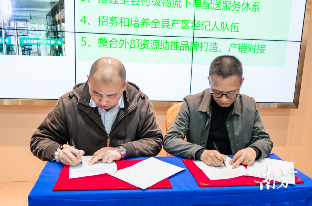  益農(nóng)信息社（仁化）運(yùn)營(yíng)中心負(fù)責(zé)人宋德坤與中國(guó)郵政集團(tuán)有限公司仁化縣分公司副總經(jīng)理江志敏進(jìn)行仁化郵政與“村品通”平臺(tái)簽約儀式