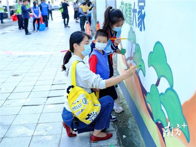 家长带着孩子一起为禁毒宣传及文明创建墙绘上颜色。李鄂 摄 家长带着孩子一起为禁毒宣传及文明创建墙绘上颜色。李鄂 摄