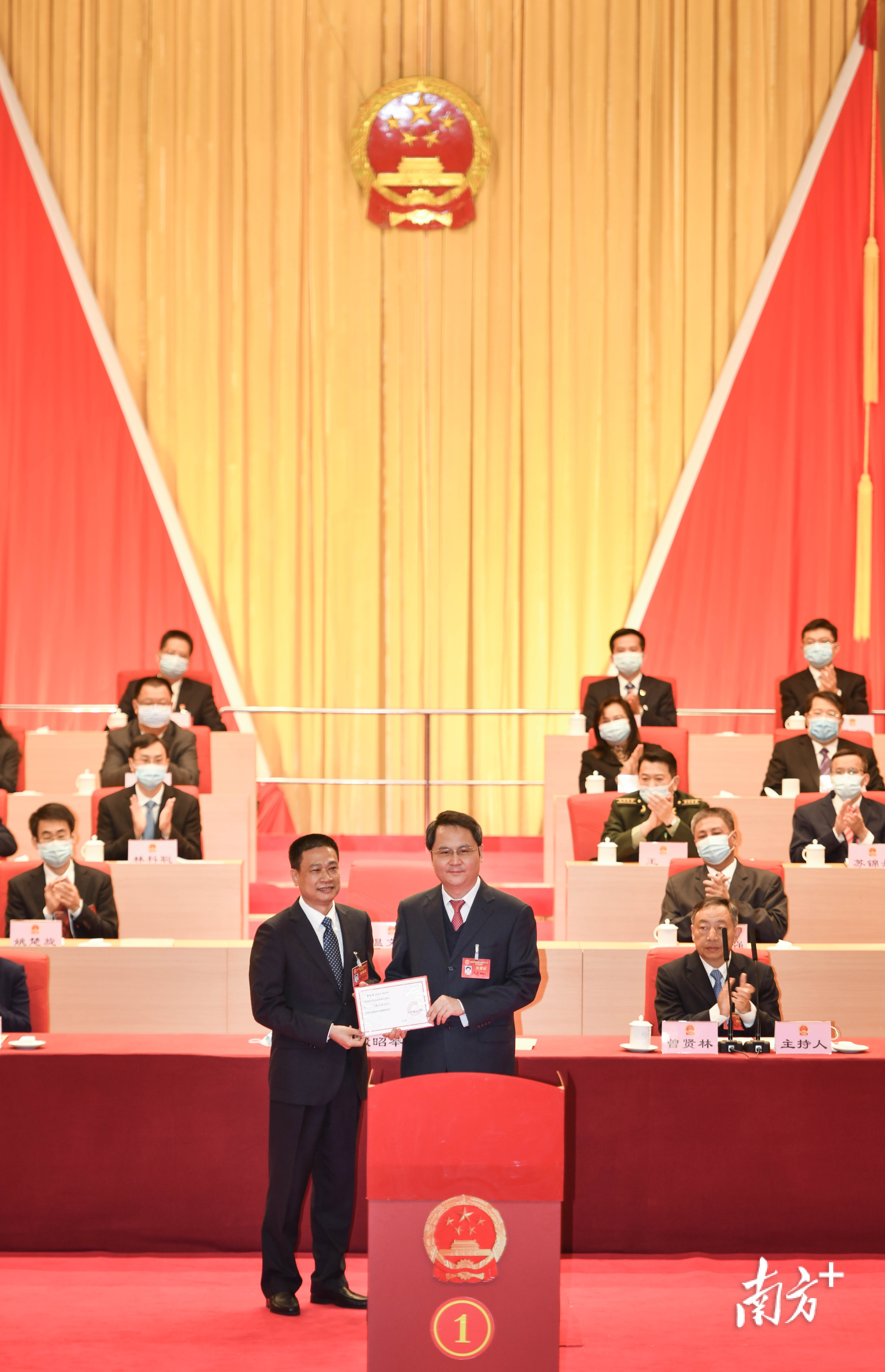 大会主席团常务主席、市委书记、市人大常委会主任殷昭举（右一）为新当选的清远市市长温文星（左一）颁发当选证书。曾亮超 摄
