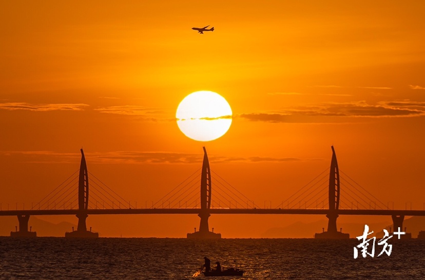12月4日，珠海港珠澳大桥迎来日出时刻，客机穿过金色的朝霞，三者连成一线。&nbsp; 南方拍客 蔡嘉鸿&nbsp;供图