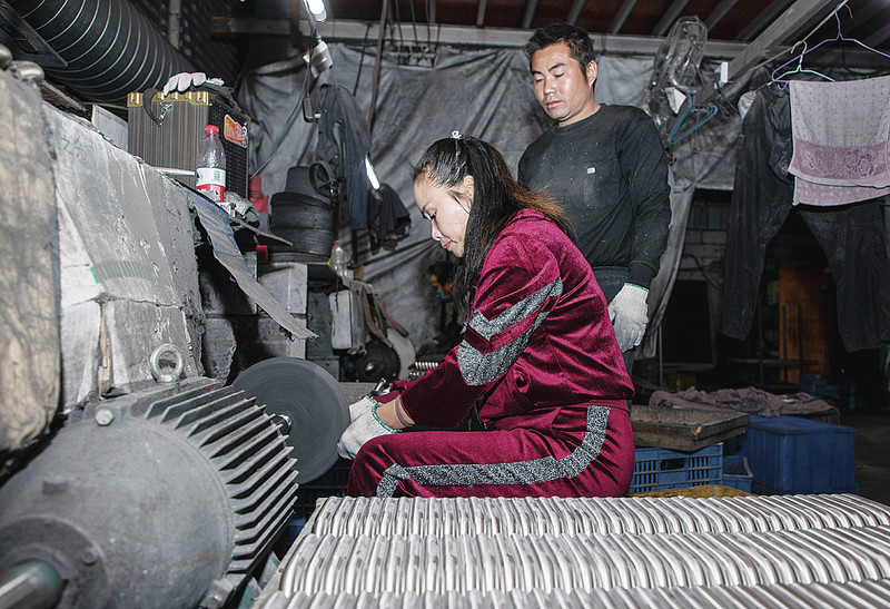 孟建英在自己的抛光厂里指导员工工作.