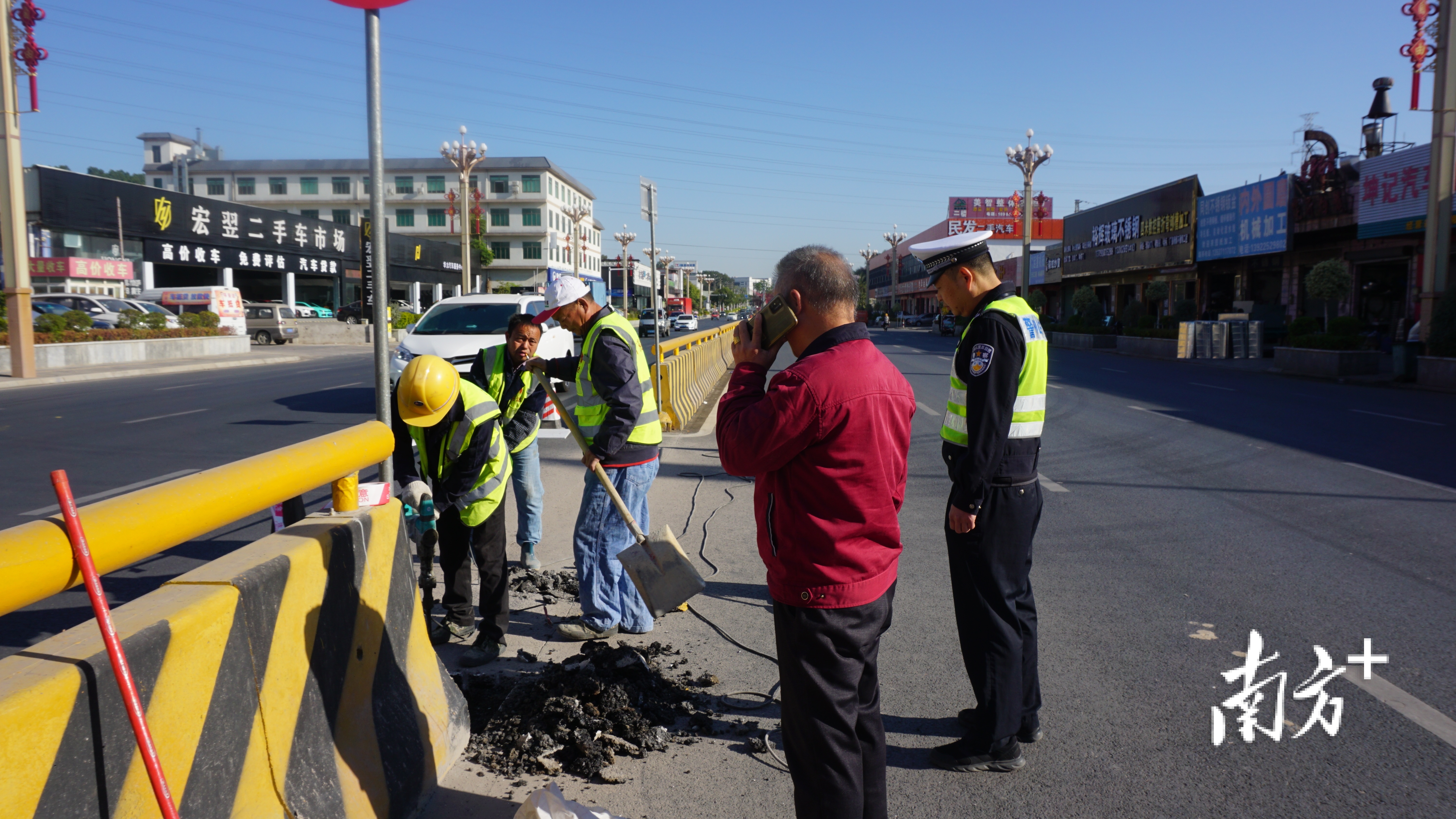 何景良监督道路中心护栏修建。