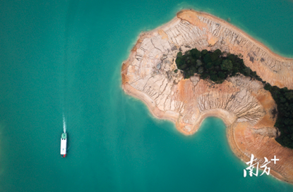 河源万绿湖上，游船驶过干涸裸露的河床。