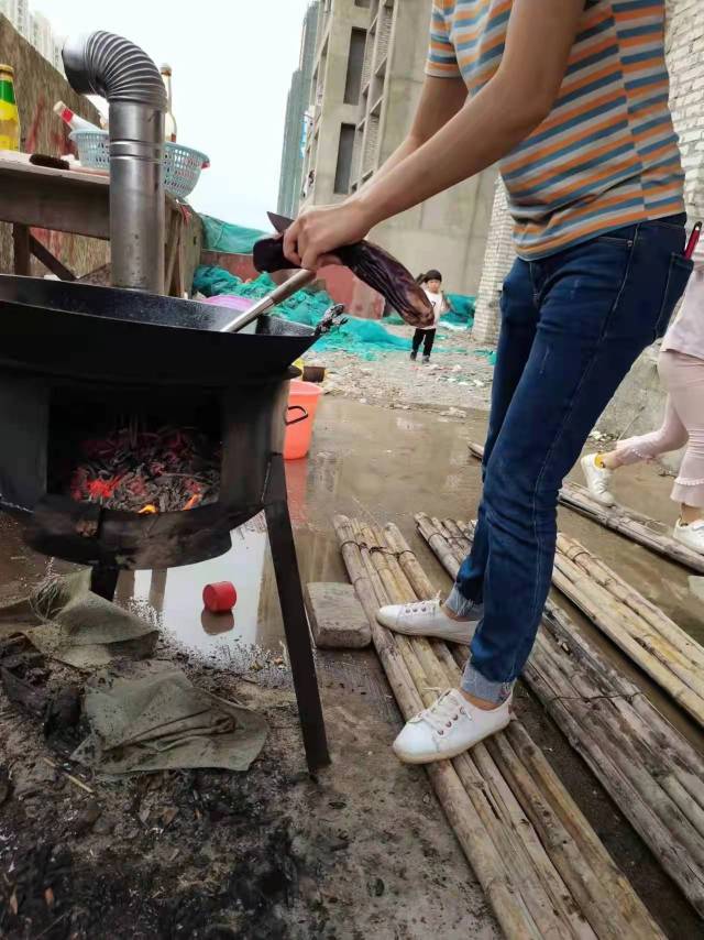 站在竹排上正做饭的业主。受访者供图