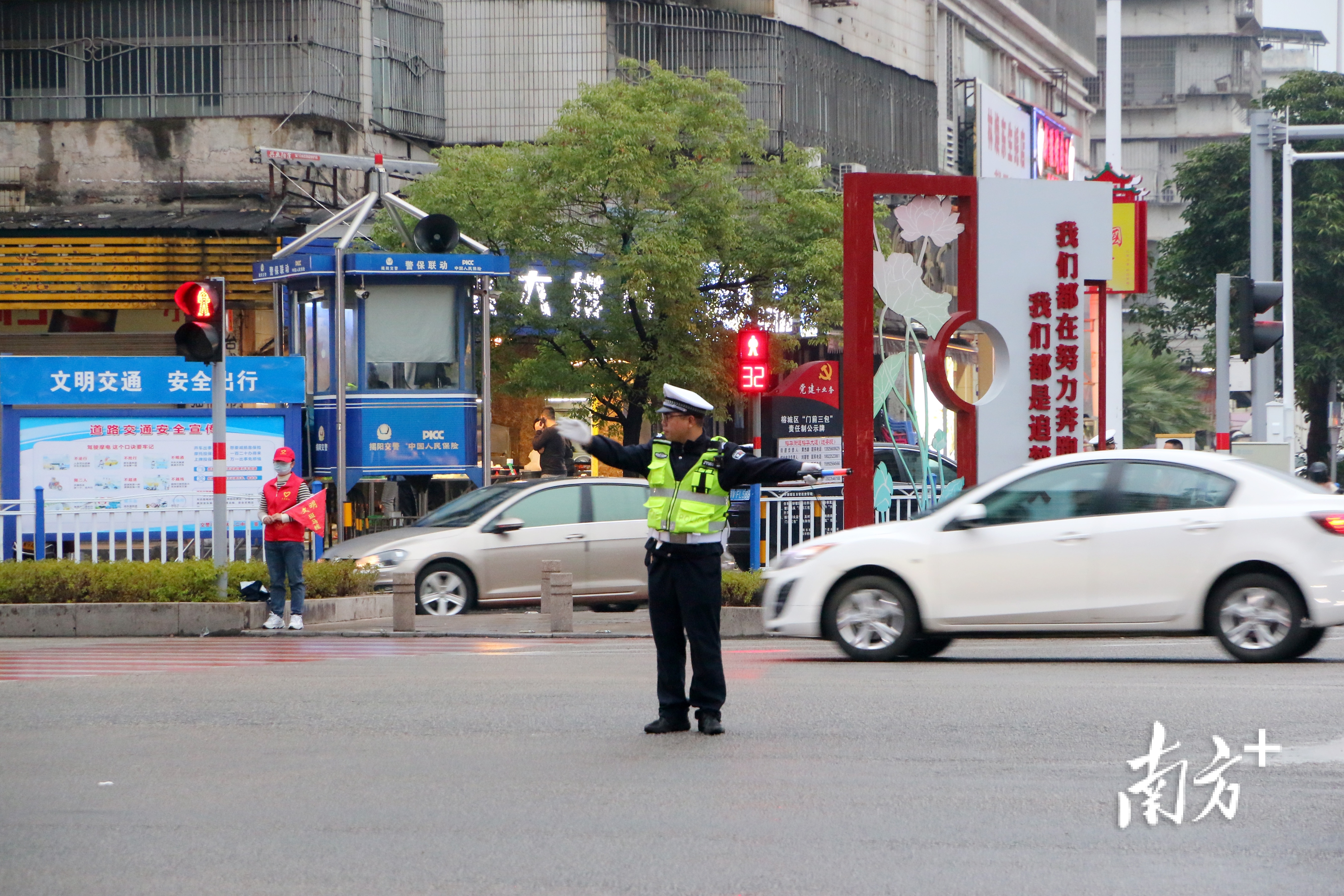 交警与志愿者在维持交通秩序,确保市民安全出行.