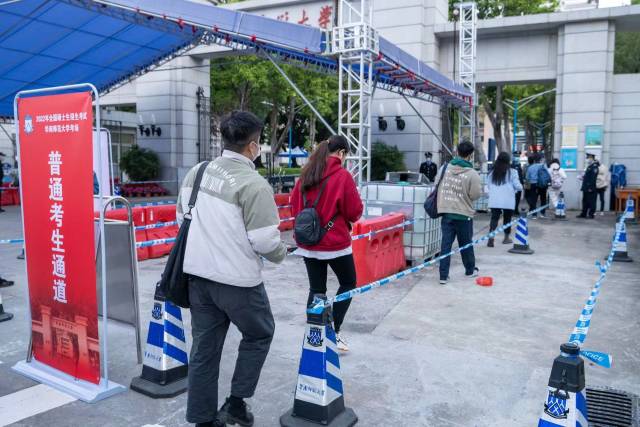 考生排队等待进入考点。 考生排队等待进入考点。