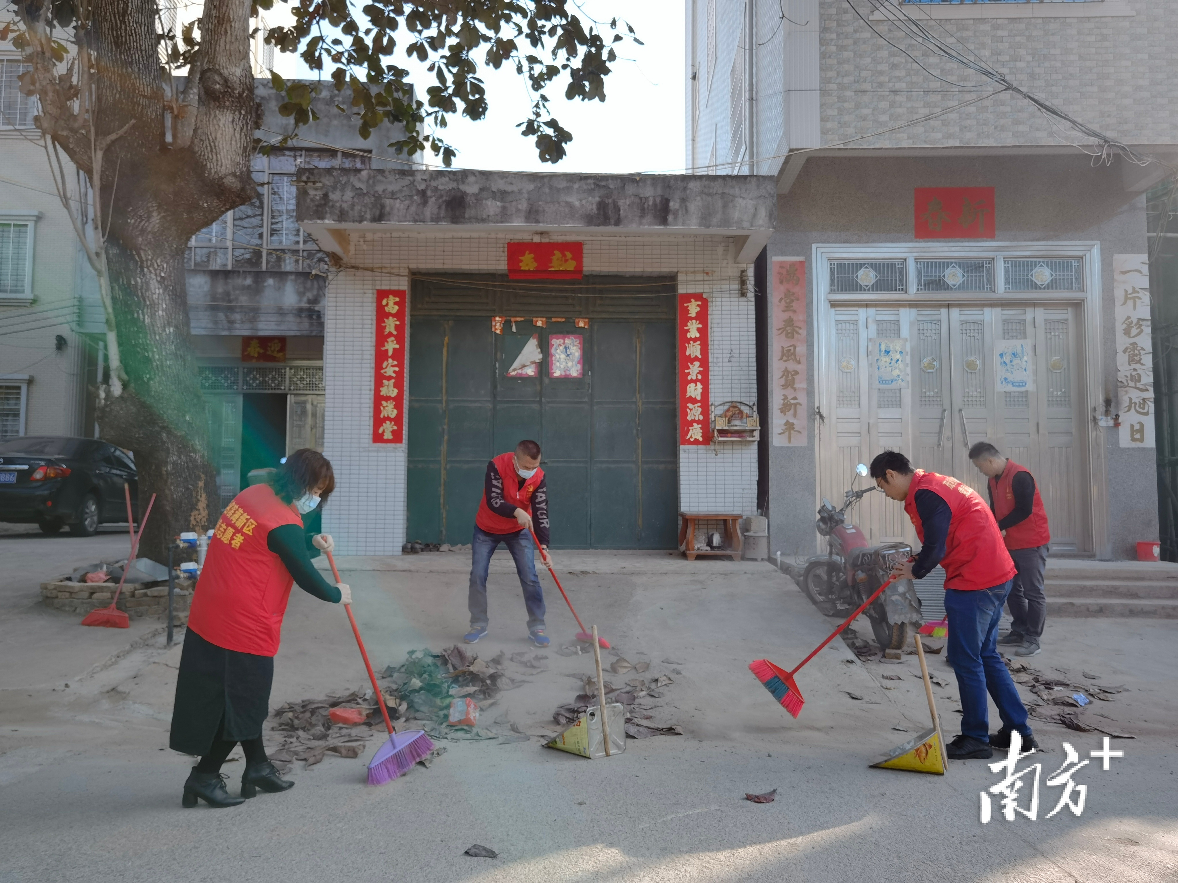 税务志愿者清扫房前屋后堆放的垃圾。 王凤仙 摄