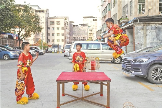 员村，广州市泰晟龙狮团的少年高高跃起准备跳上台面。