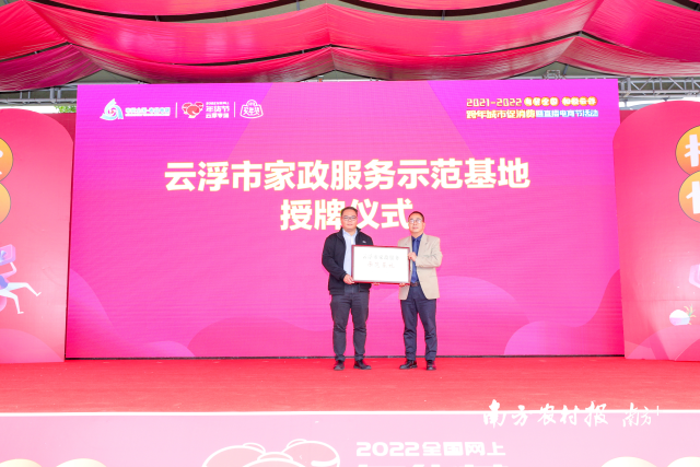 云浮市商务局副局长陈志远（右）为云浮市家政服务示范基地授牌。