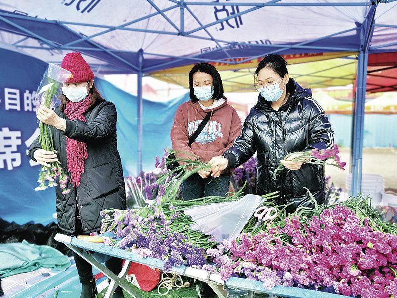 厂排疏导区迎春花市的工作人员在准备鲜花销售。