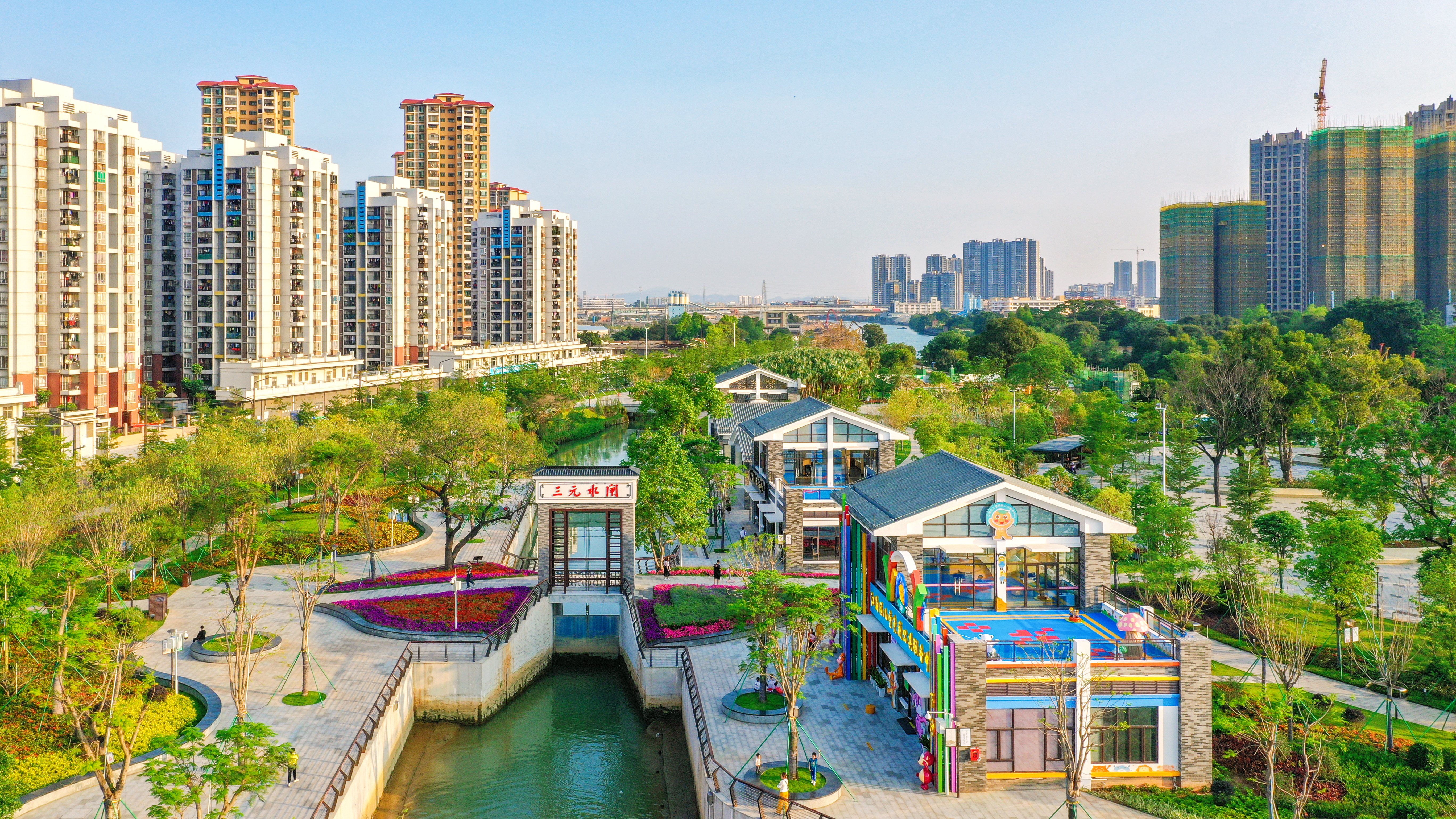 江海下沙公园里，经“三旧”改造后，棚户区变风景区：河水蜿蜒，亭台掩映绿树间，一架天桥飞跃两岸。陈立武 摄