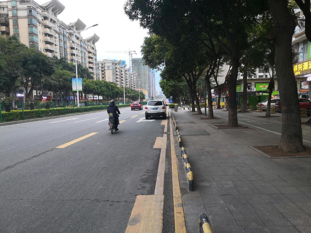 ▲一辆电动车行驶在宏图路公交专用道上，附近一辆小汽车违规占用公交专用道。