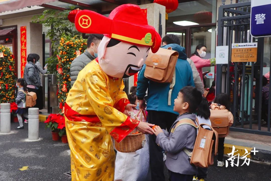 松山湖翰林湖家禾幼儿园的“财神爷”为孩子们派发橘子。