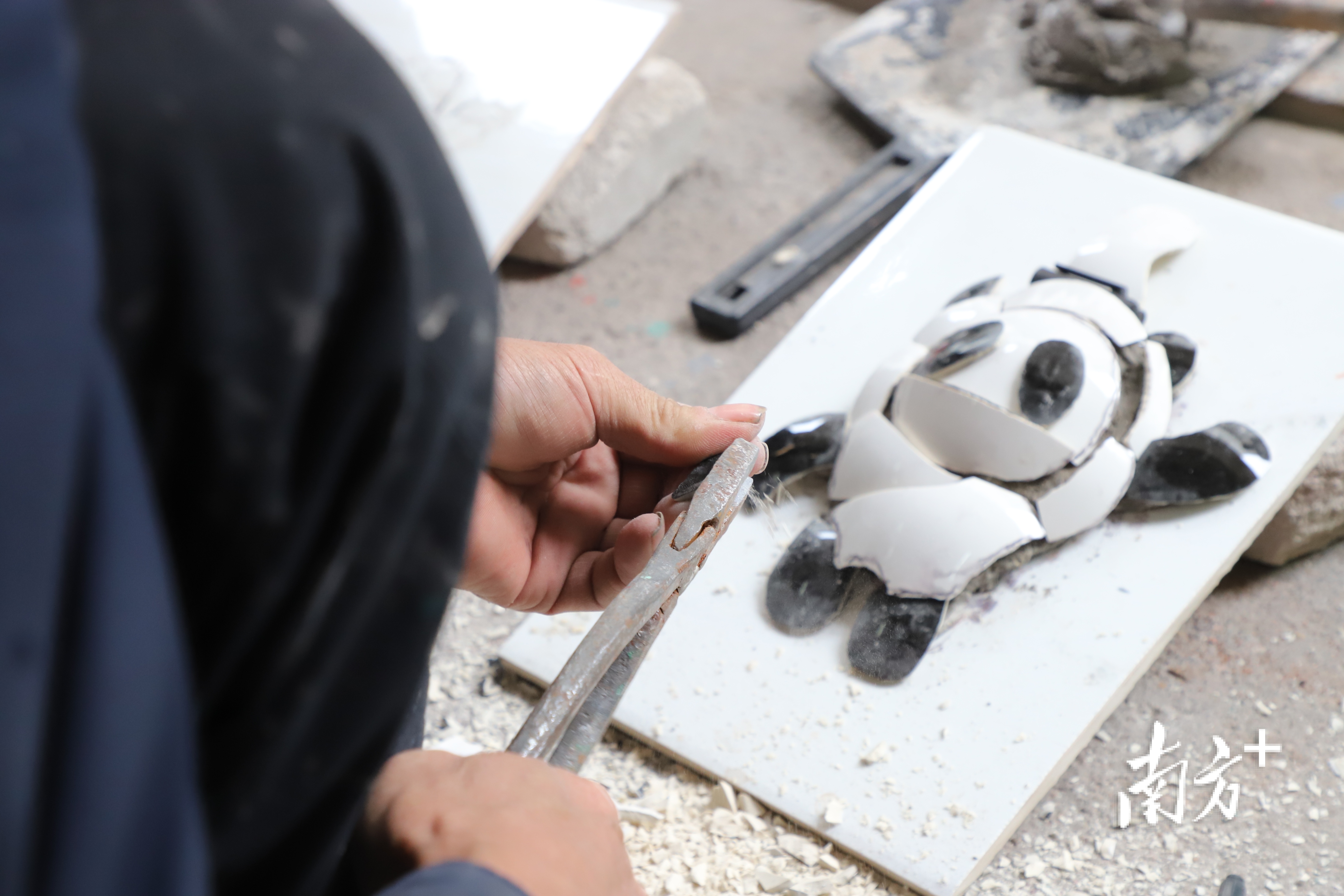 蔡炳烈正在制作嵌瓷版“冰墩墩”。