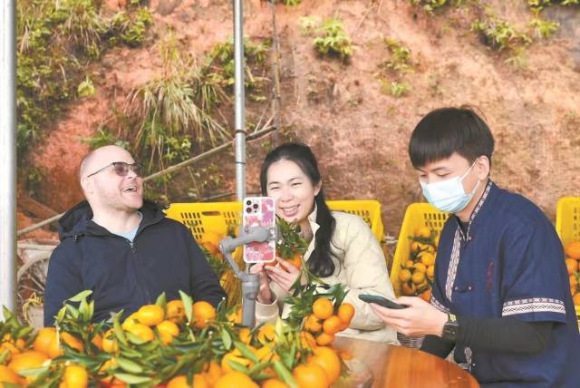 陈慧（右二）带领跨国直播团助力河源柑橘销售