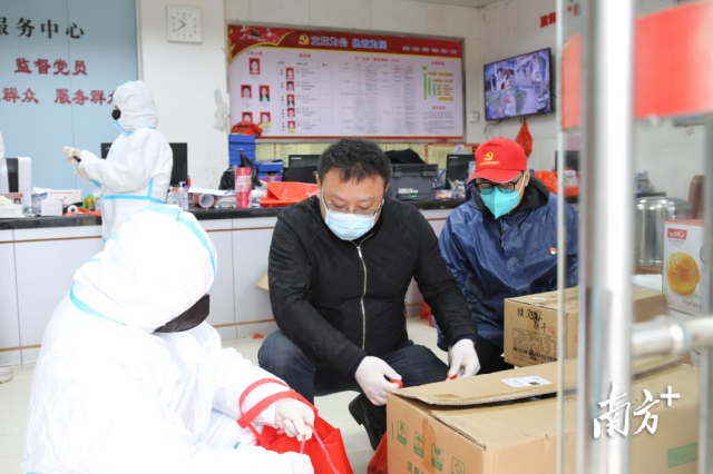 颜贵吉(中)正在旗垌村村委盘点物资