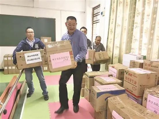 崔现忠(前排中间)为渔涝镇捐赠图书等物资。(受访者供图) 崔现忠(前排中间)为渔涝镇捐赠图书等物资。(受访者供图)