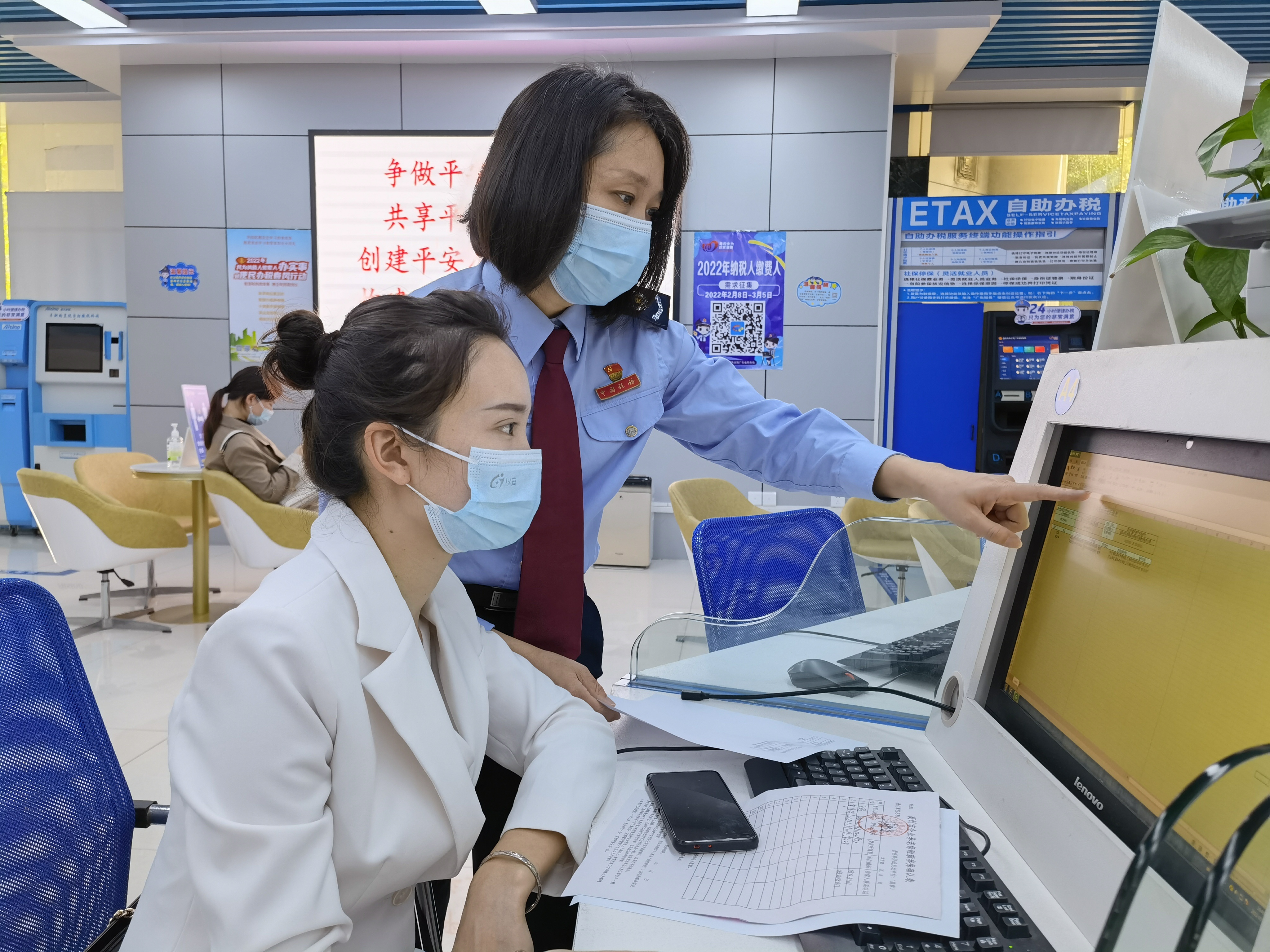 钟晓玲正在辅导纳税人登录电子税务局办理相关涉税业务。吴秋颖 摄