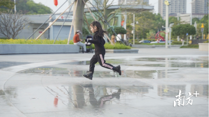 小朋友在黄旗山公园正门广场新修建的喷泉上玩耍。 何绮莹摄