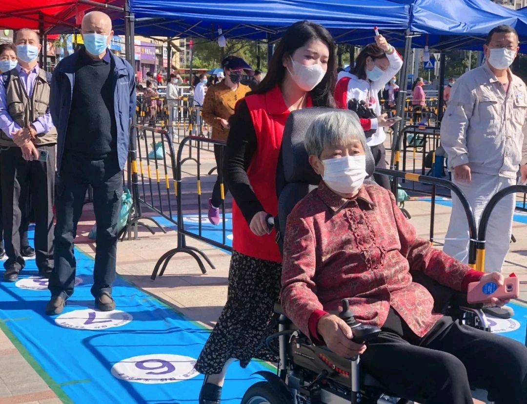 大亚湾志愿者协助老人参与核酸采样。