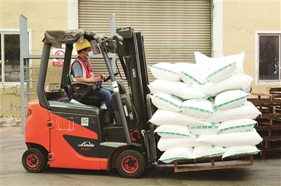 望牛墩镇立顿洗涤公司内,工人戴着口罩开叉车.