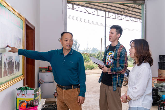 覃斗镇铺前村农业种植专业合作社理事长陈朋（左一）向记者介绍合作社情况。