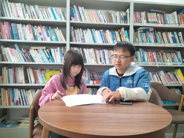 黄海淦在辅导小学生功课