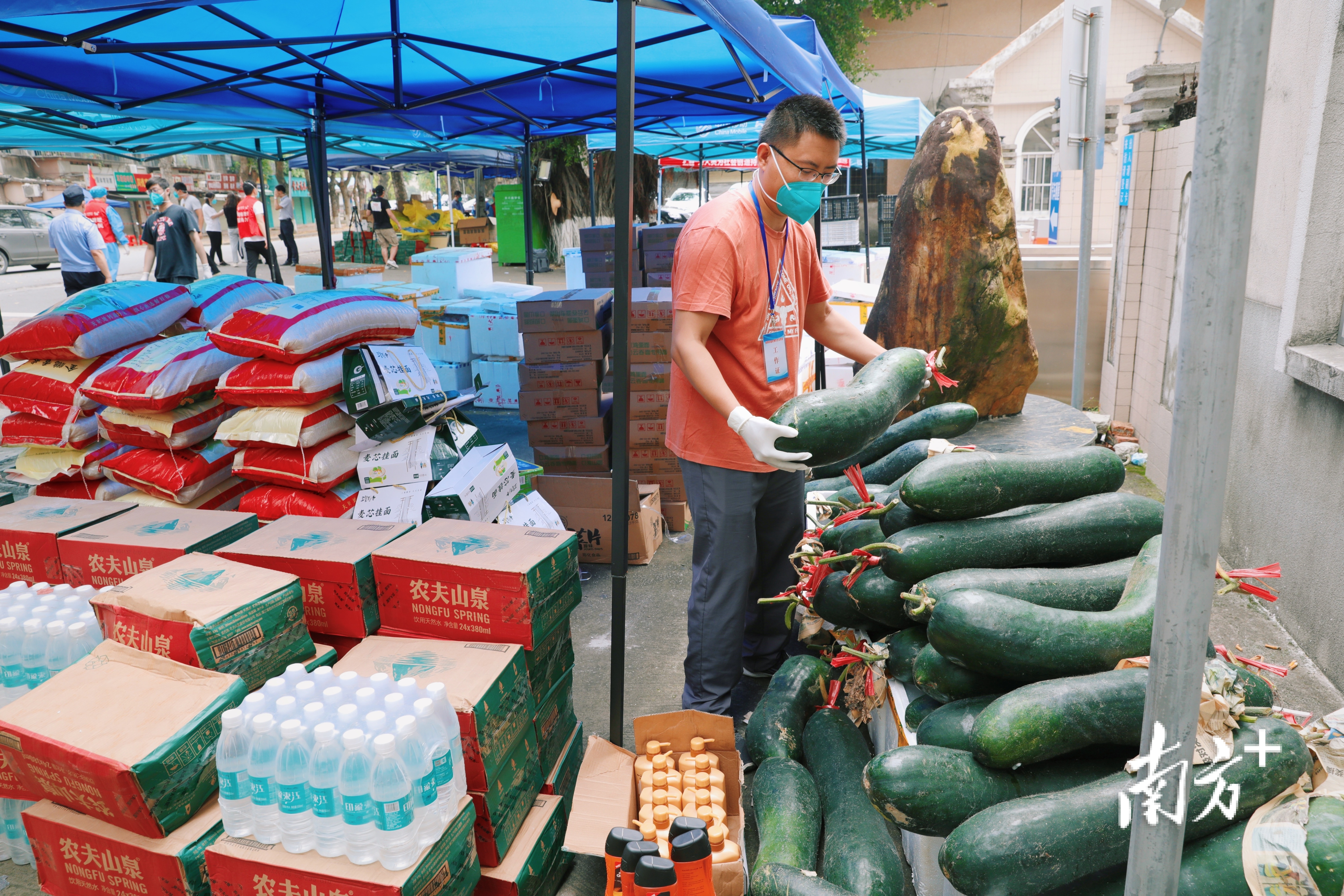 坡头区南调街道南油三区文明居南区门口，工作人员在装卸物资，准备配送。