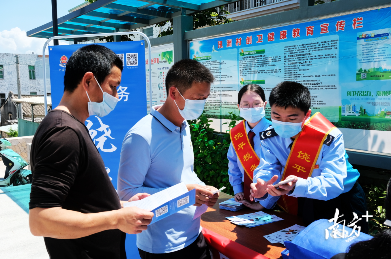 饶平县税务局饶税青年党员向群众派发宣传资料。受访者供图