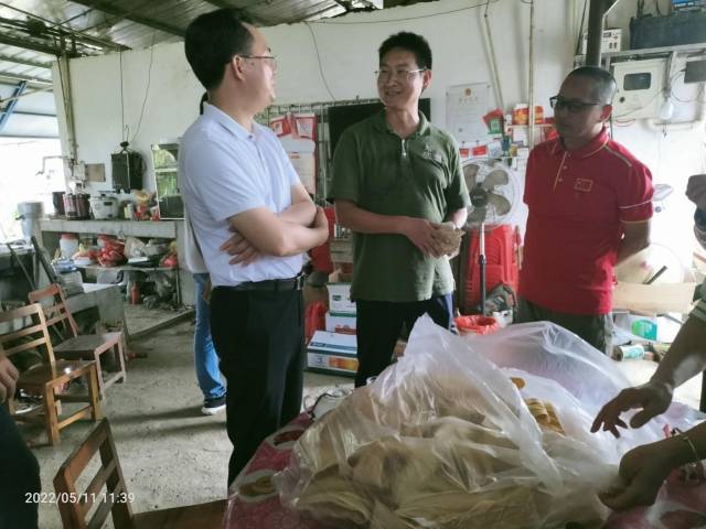 程艳波博士与陈达健镇长在现场仔细品鉴当地生产的腐竹。