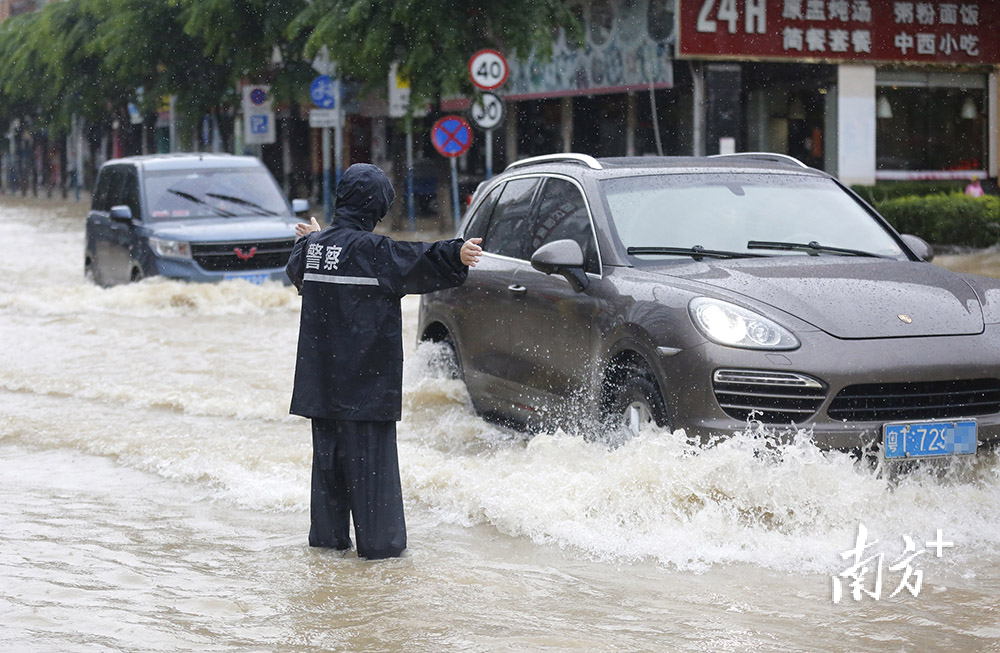 2022年5月12日，三乡镇宝元大道。警务人员在积水中指挥交通。&nbsp;