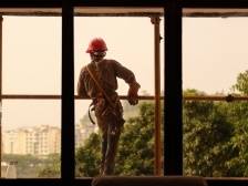 脚手架上眺望城市的年轻建筑工人