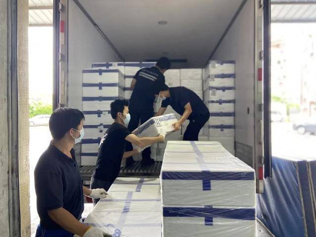 工人们将广东荔枝、杨梅等应季农产品搬上中远海运冷链车。