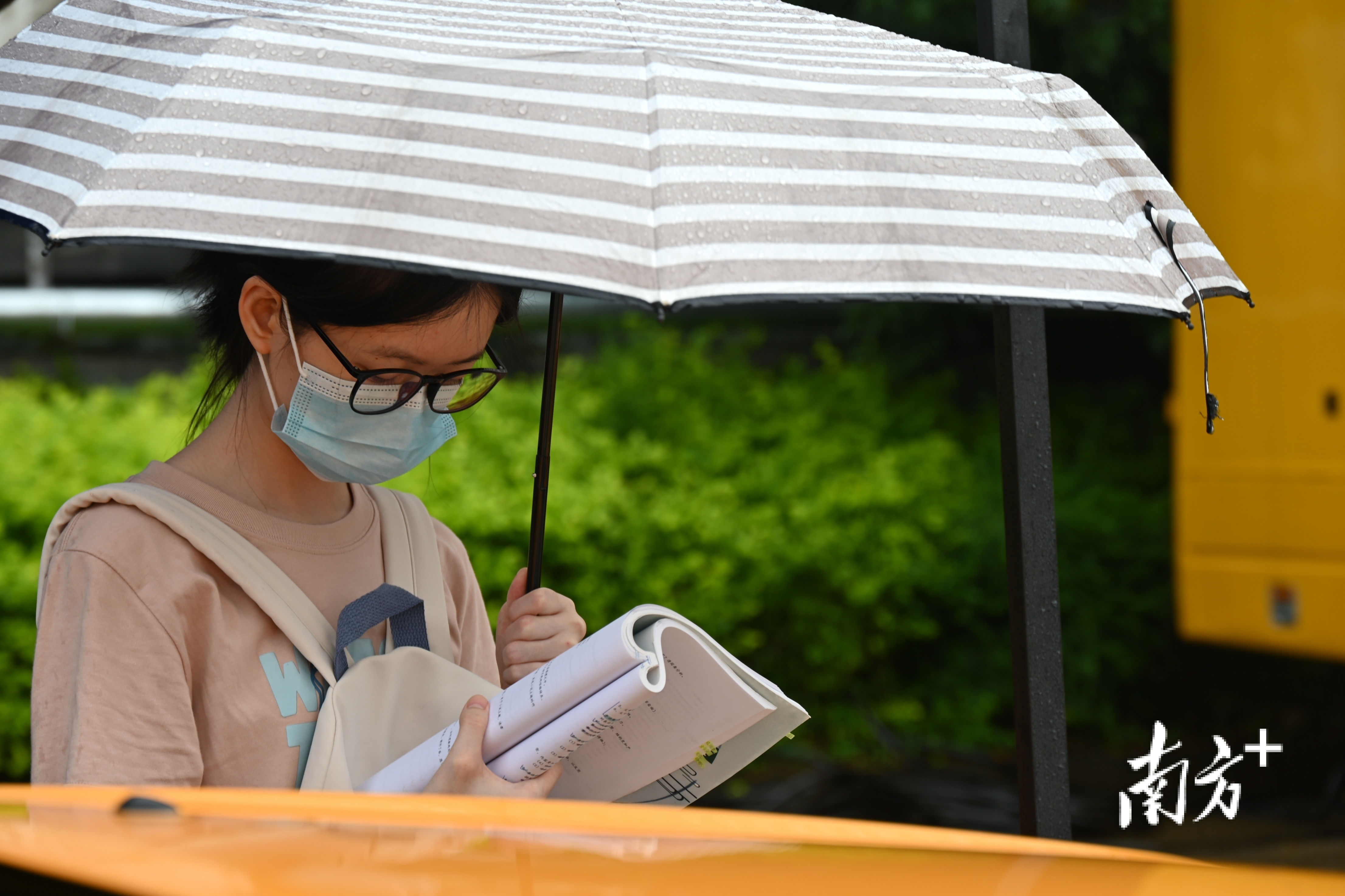 连州中学考点一角，撑伞的考生正抓紧时间温习考点知识。张晓欣 摄