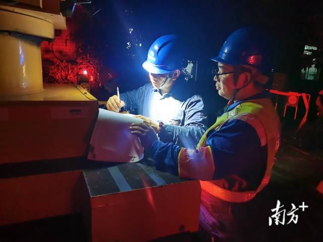 南方电网广东佛山供电局狮山供电所抢修人员在现场查看线路图。卢铭基 摄