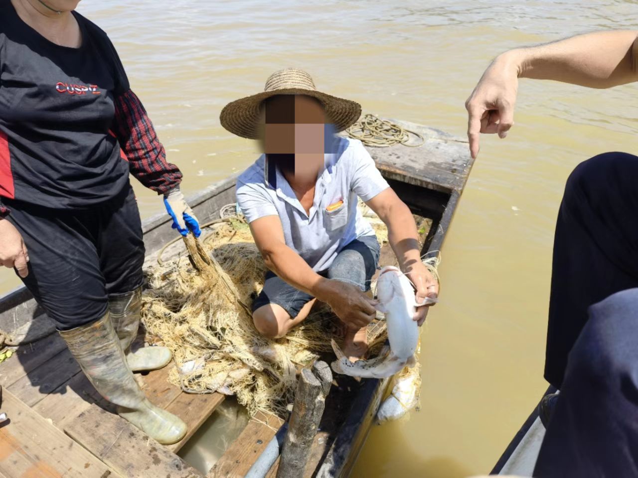 工作人员责令渔民将误捕的西江钳鱼（国家二级保护动物）现场放生。