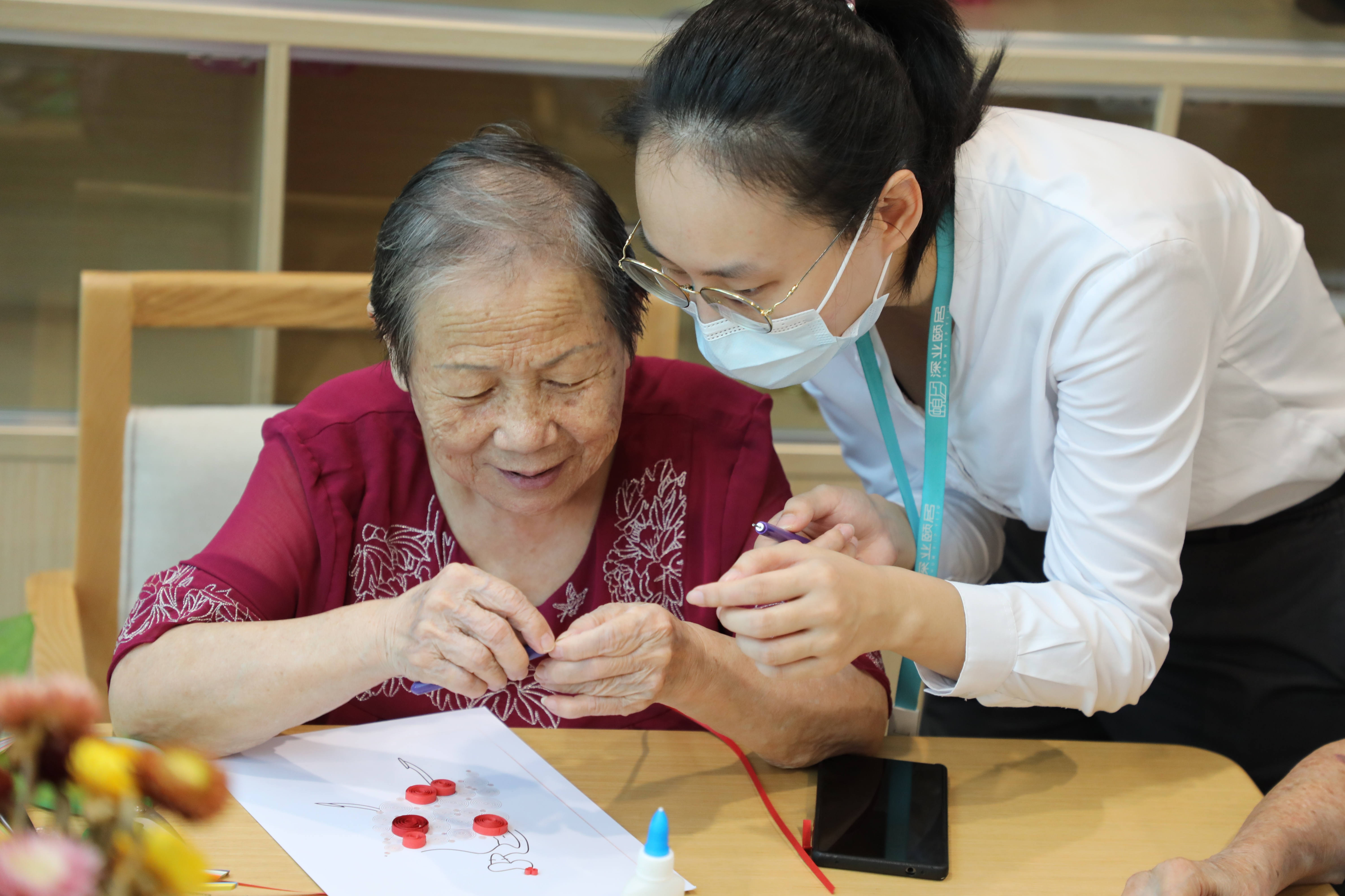 入住深业颐居的长者在工作人员陪伴下体验手工乐趣。