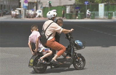 广州街头,市民骑电动车超载上路.邱伟荣 摄