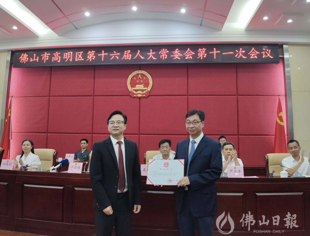 人大常委会主任谭应佳(左一)为区审计局局长谢海文(右一)颁发任命证书