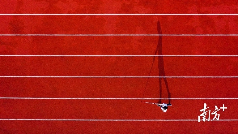 杨晓婷手持盲杖行走在潮汕职业技术学院校园内。