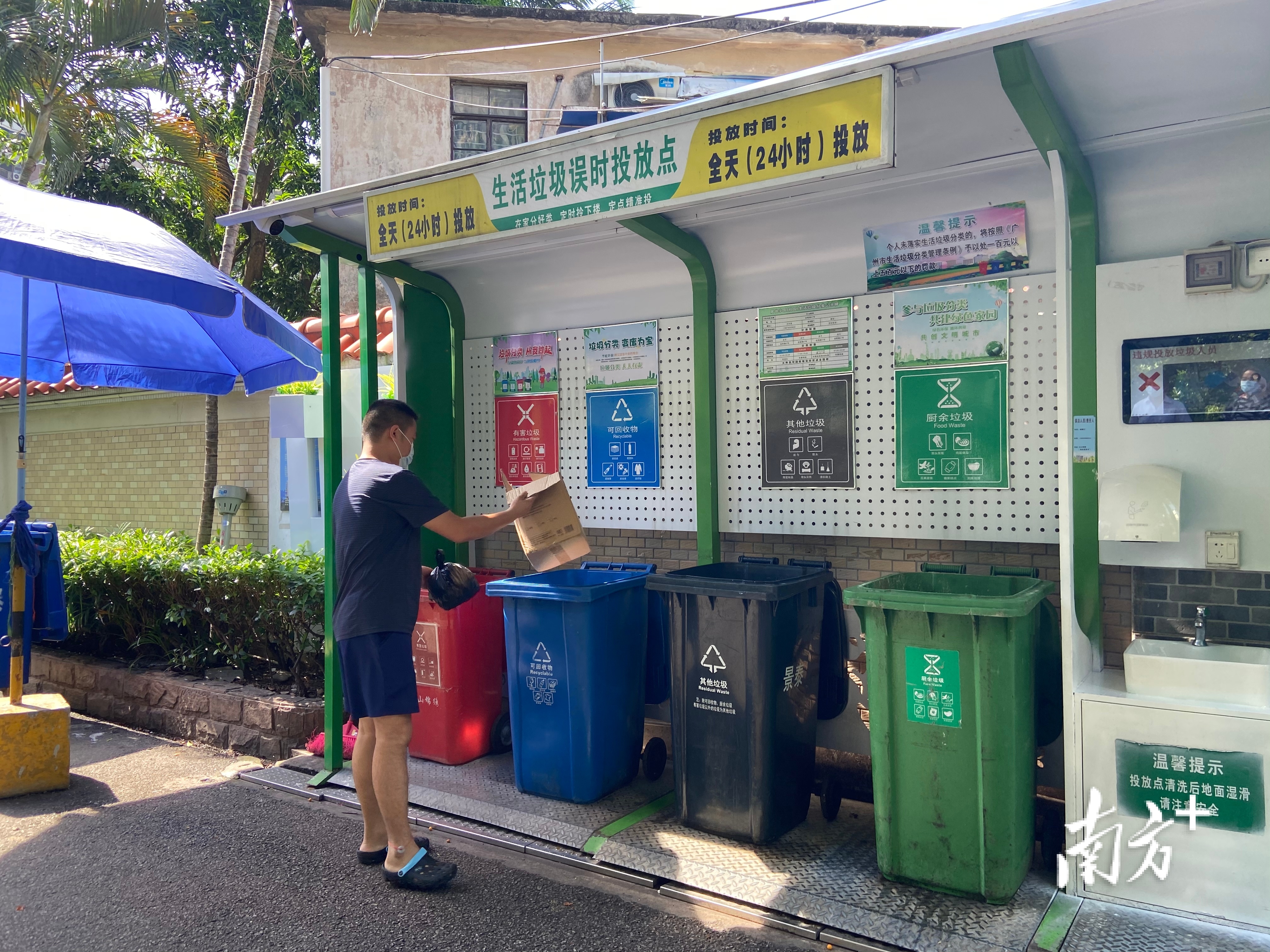 在白云区景泰街云山锦绣小区的误时投放点,居民按指引投放垃圾。